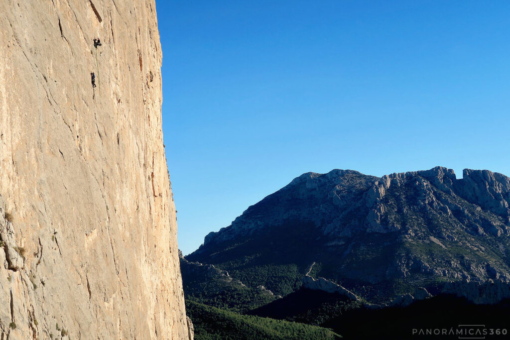 Una cordada escalando La Taula. Puig Campana detrás