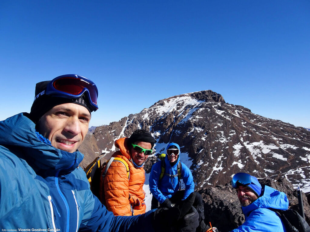 Vicente, Omar, yo y Darwin en la cumbre del Toubkal oeste. El Toubkal al fondo