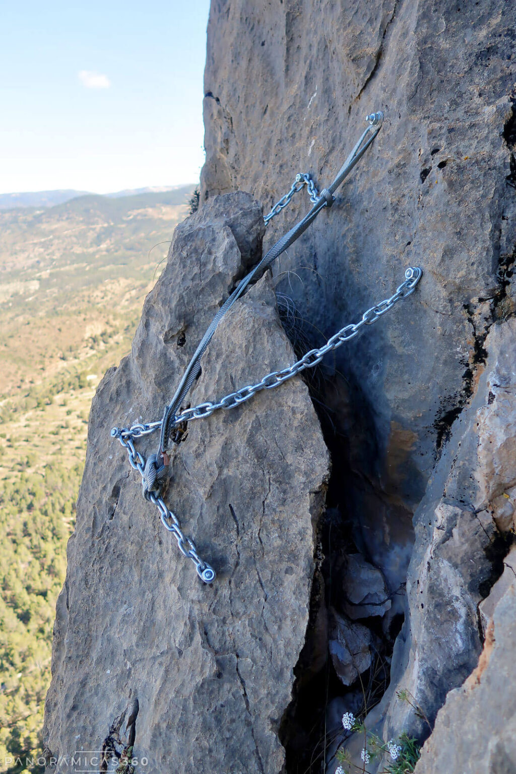Bloque de roca muy precario sujeto con varias cadenas