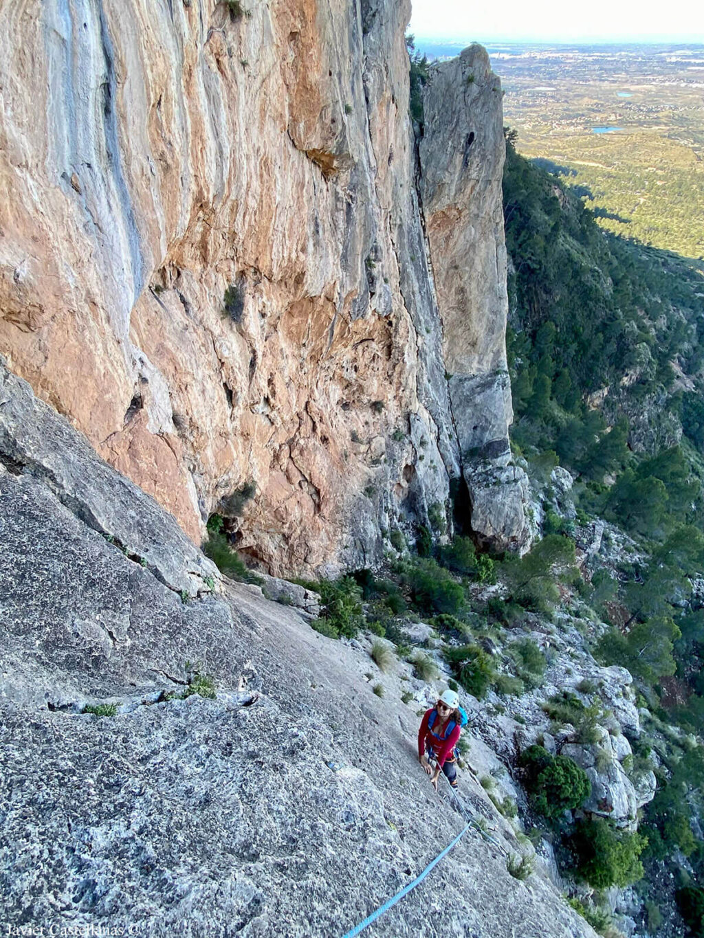 Eva escala el primer largo. El Torreón de la Mina detrás