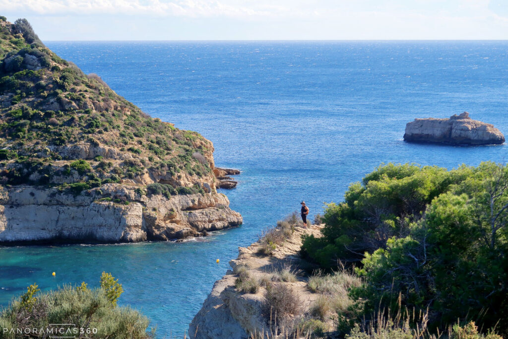 Cris camina junto al acantilado. Isla del Portitxol detrás